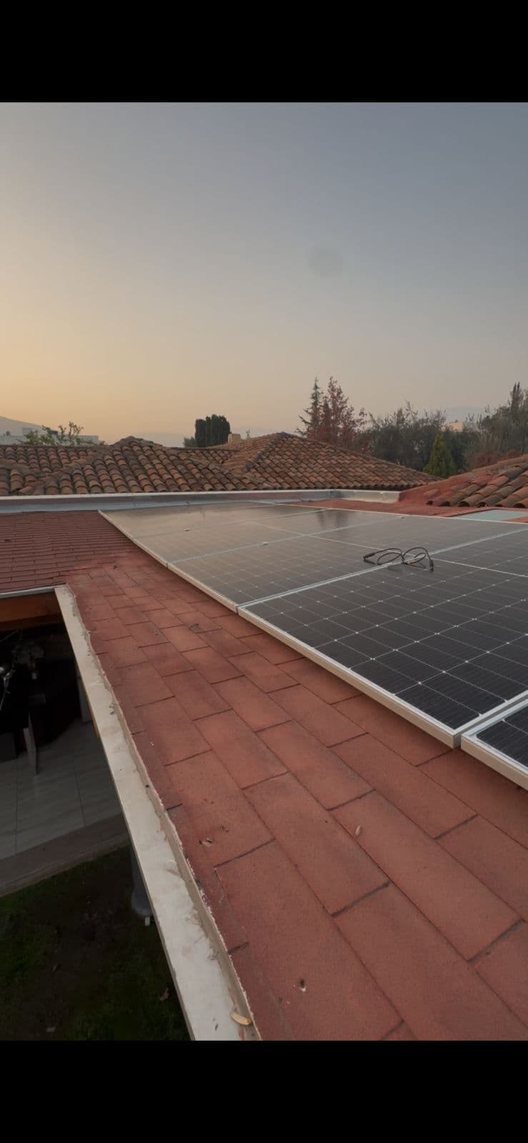 Paneles solares sobre tejas al atardecer